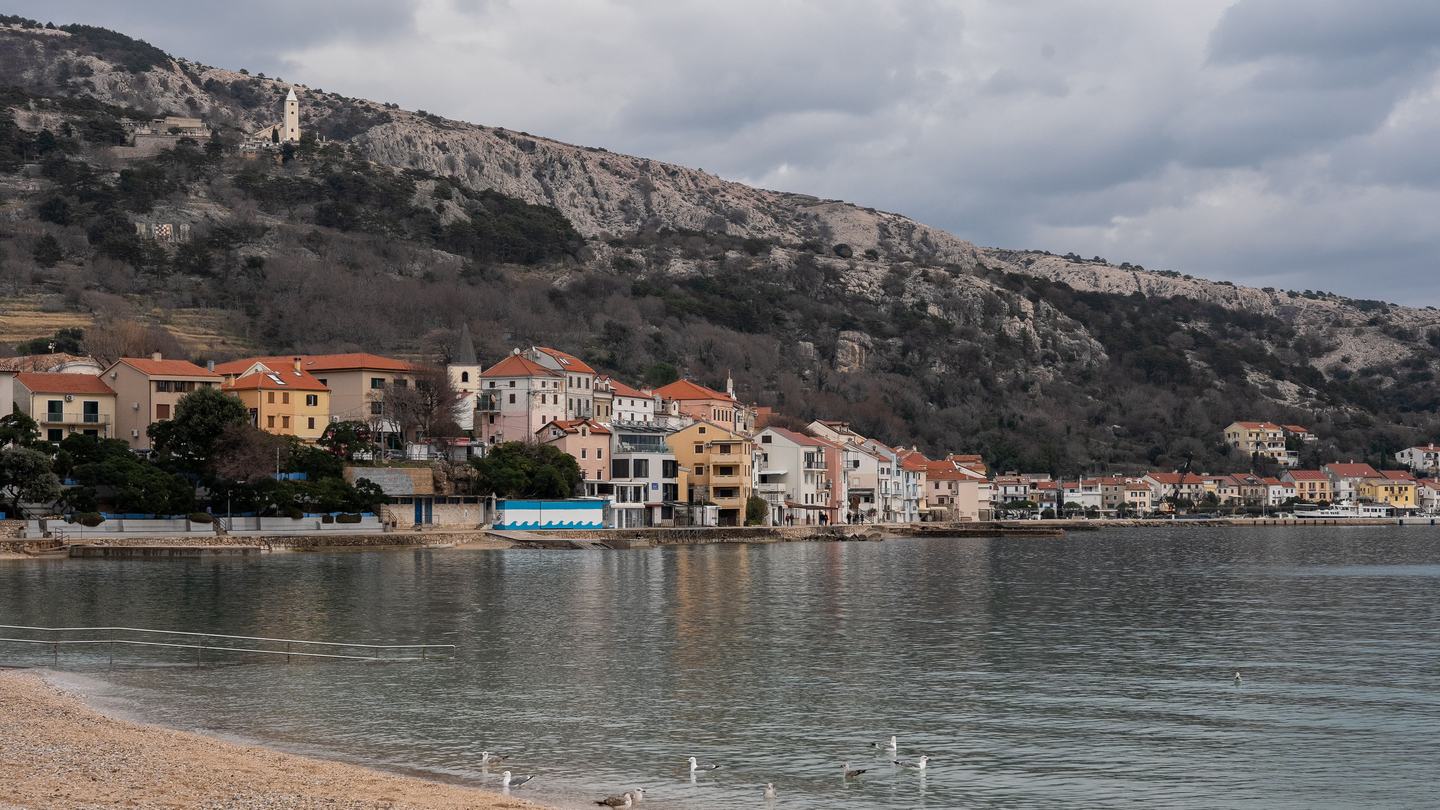 Baška auf Krk außerhalb der Saison, hinter der Altstadt der kahle Karstrücken
