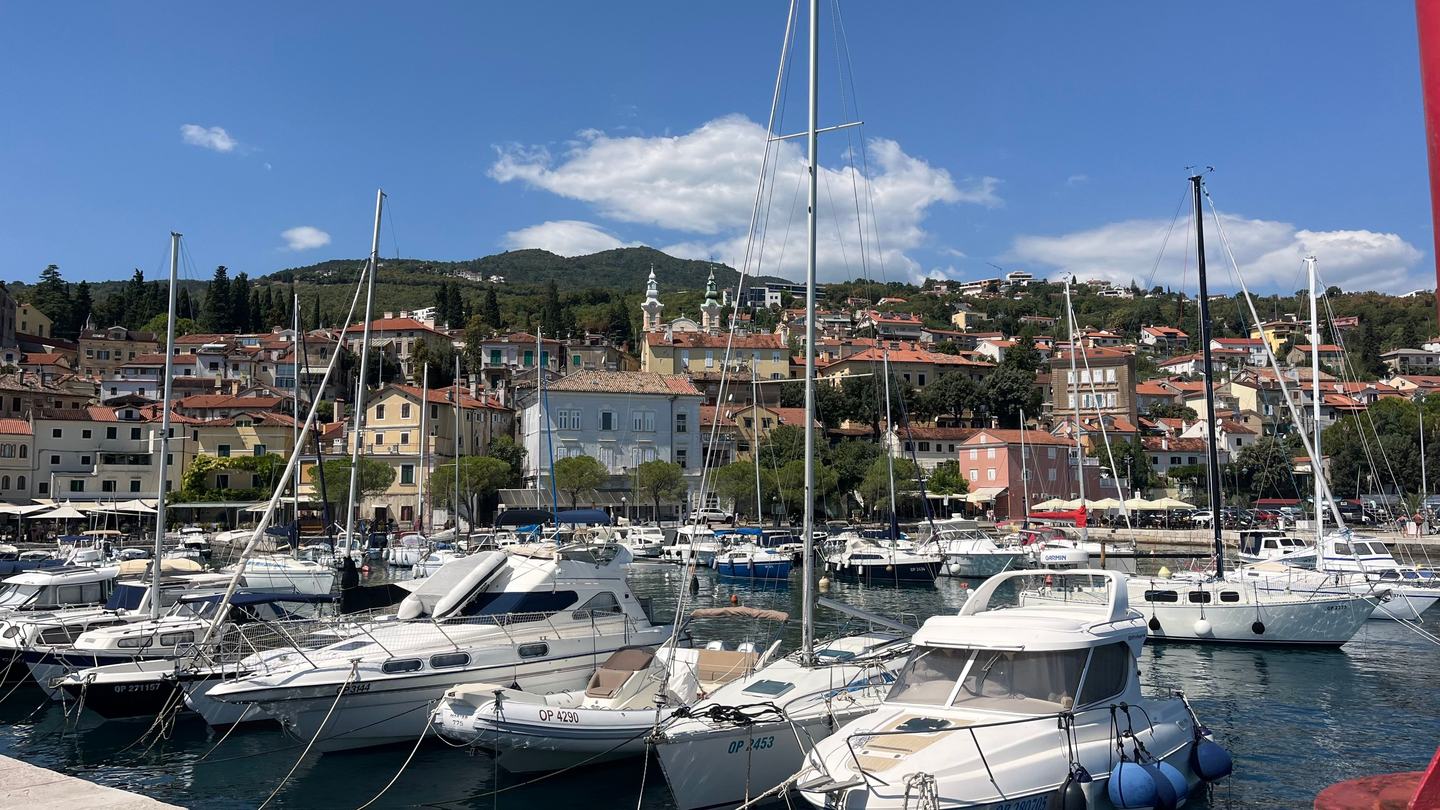 Der Hafen von Lovran mit Booten, dahinter der Ort am Hang der Učka