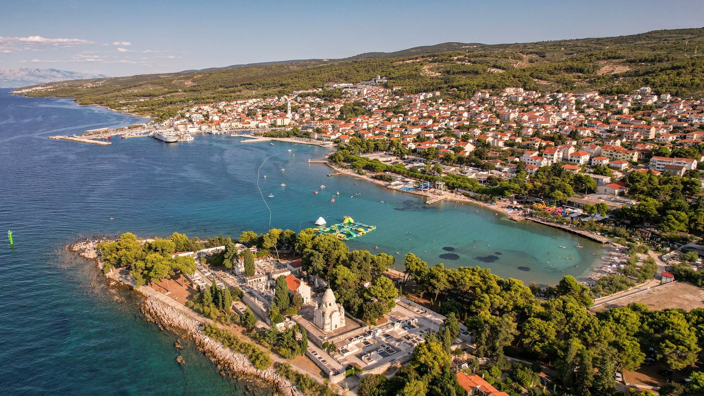 Novalja auf der Insel Pag aus der Luft, die Bucht und der Stadtstrand in der Hochsaison