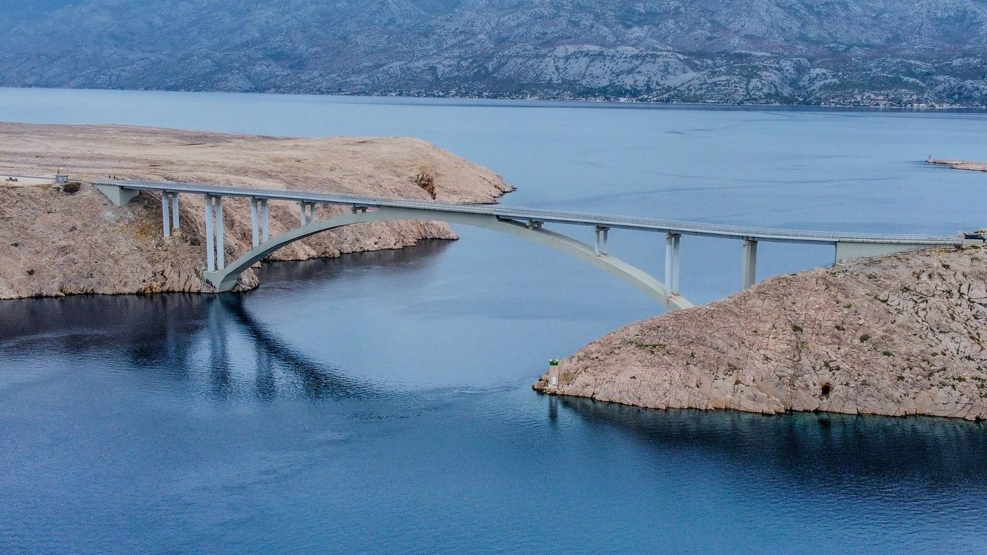Die Pag-Brücke über den Kanal, beiderseits des Wassers kahler Karst