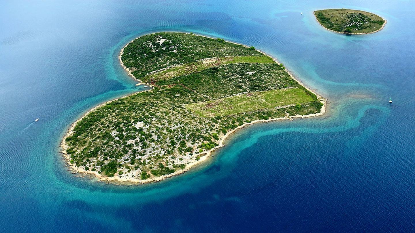 Eine Insel vor Pakoštane, alte Feldterrassen und Trockenmauern über flachem Wasser