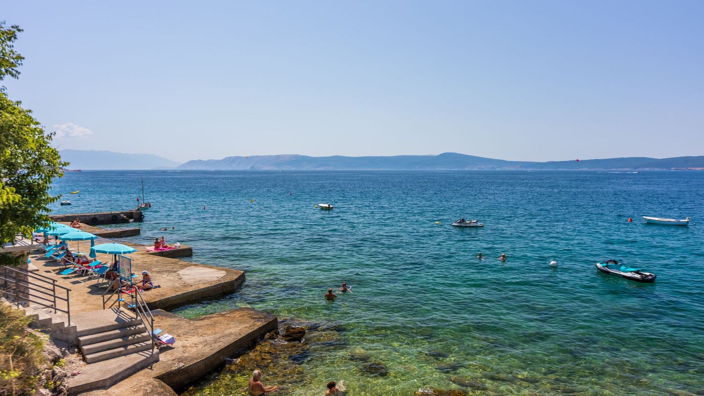 In den Fels geschlagene Badeplattformen in Selce, gegenüber die Insel Krk