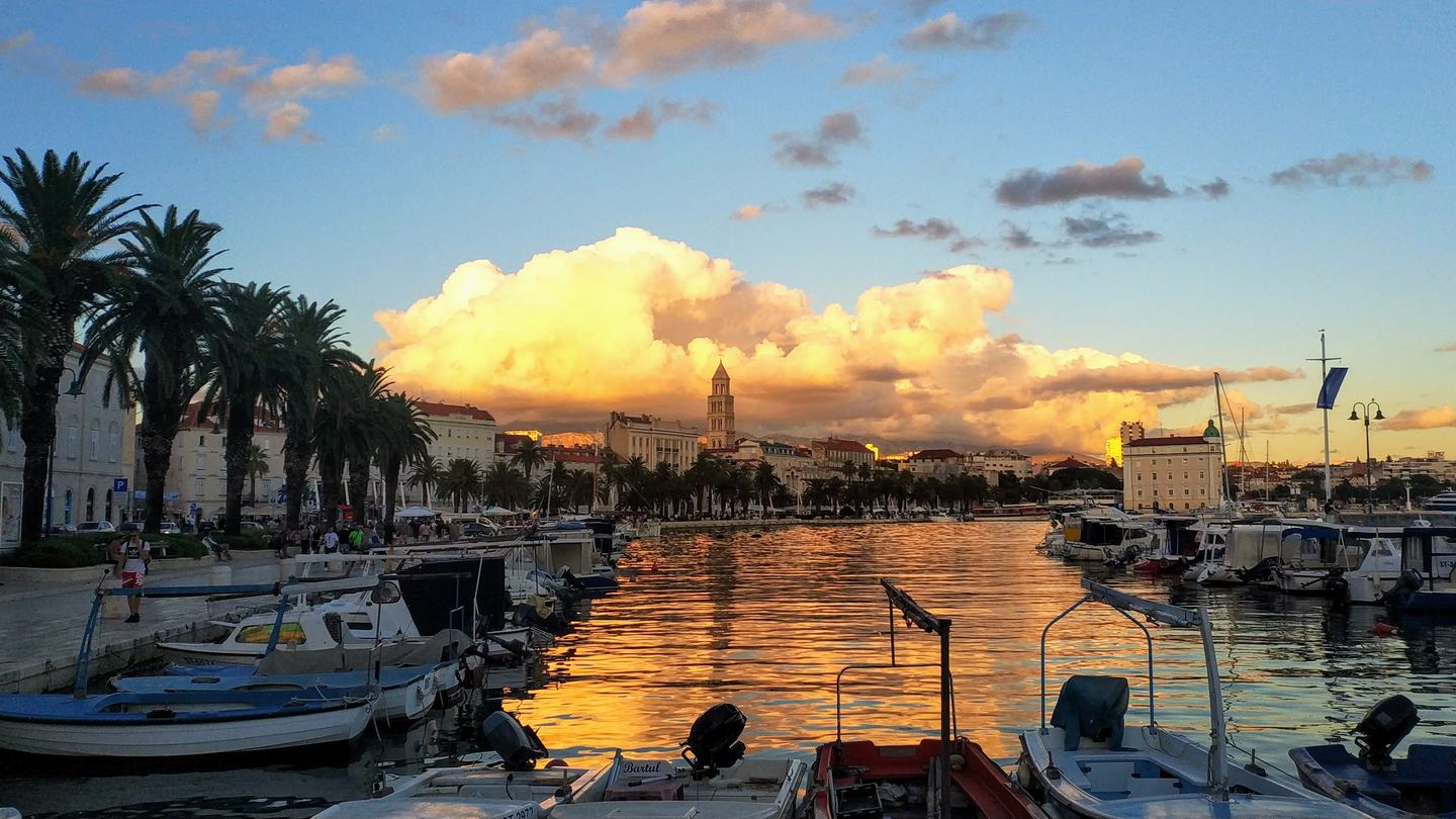Die Riva von Split bei Sonnenuntergang, hinter den vertäuten Booten der Glockenturm des Diokletianspalasts