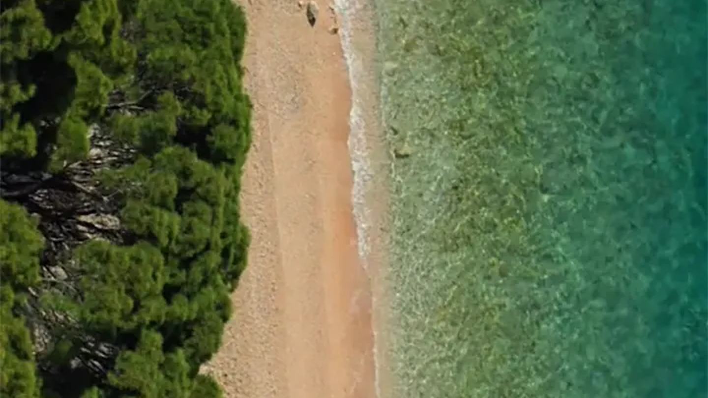 Der Strand von Tučepi direkt von oben: Pinienwald, Kies und klares Wasser