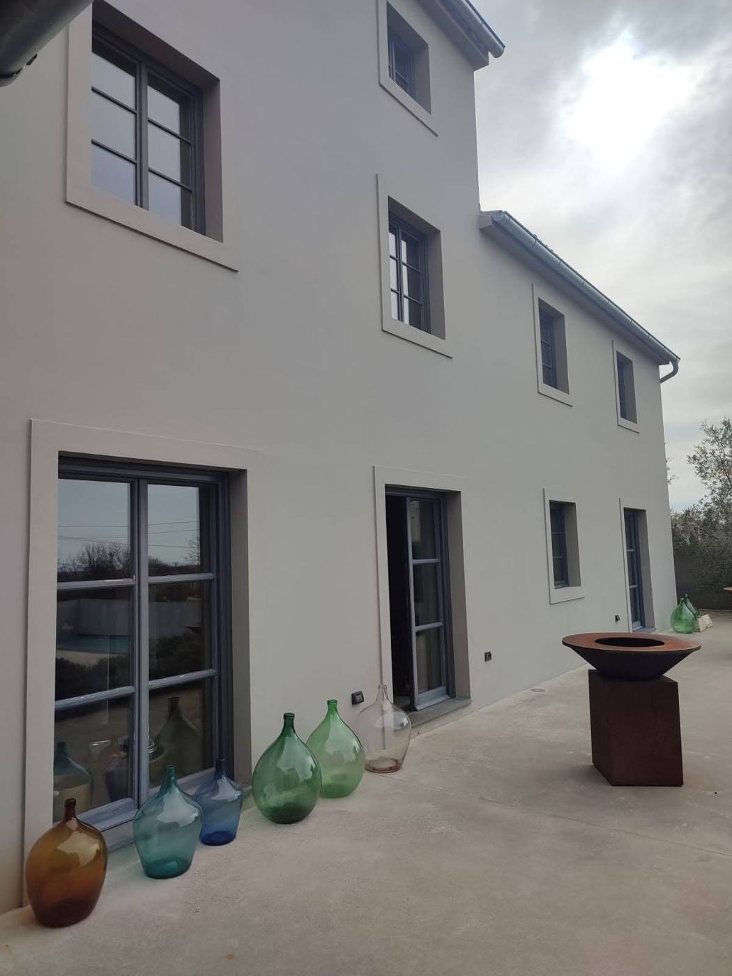 Der fertige Putz an einem Haus, die Fensterlaibungen sauber, die Terrasse gekehrt, am Ende einer Renovierung